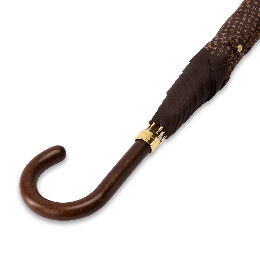 Close-up engraved gold metallic hardware on a luxury designer rain umbrella